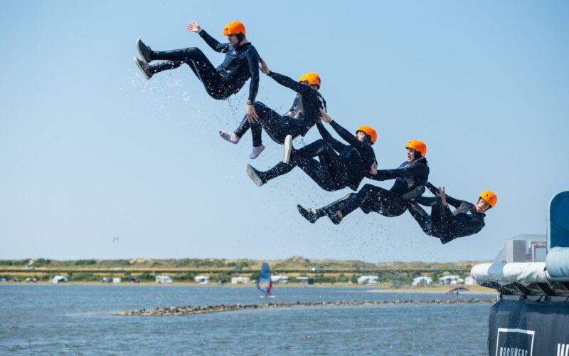 Mensen gaan van een schans af in het water.