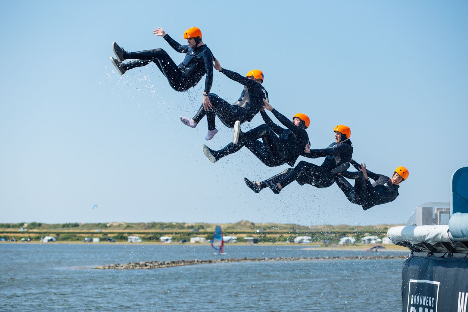 Mensen gaan van een schans af in het water.